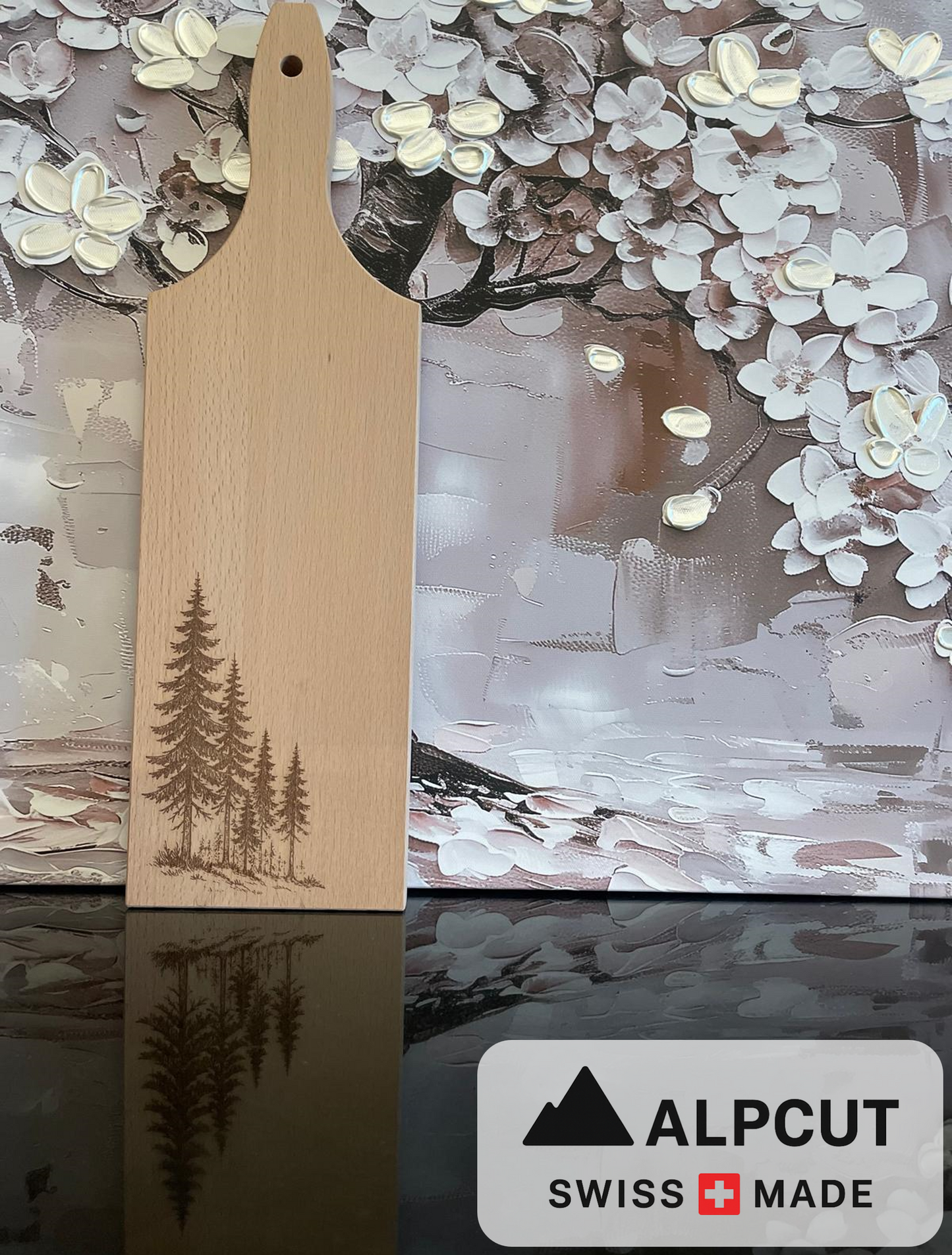 „Schneidebrett aus Schweizer Buchenholz mit Griff und Gravur von Tannenbäumen – handgefertigt von ALPCUT. Nachhaltiges Holzbrett mit feiner Maserung, ideal als Käsebrett, Servierbrett oder Geschenk für Natur- und Alpenliebhaber. Hochwertige Swiss Made Qualität, langlebig, dekorativ und funktional für Küche und Esstisch.“