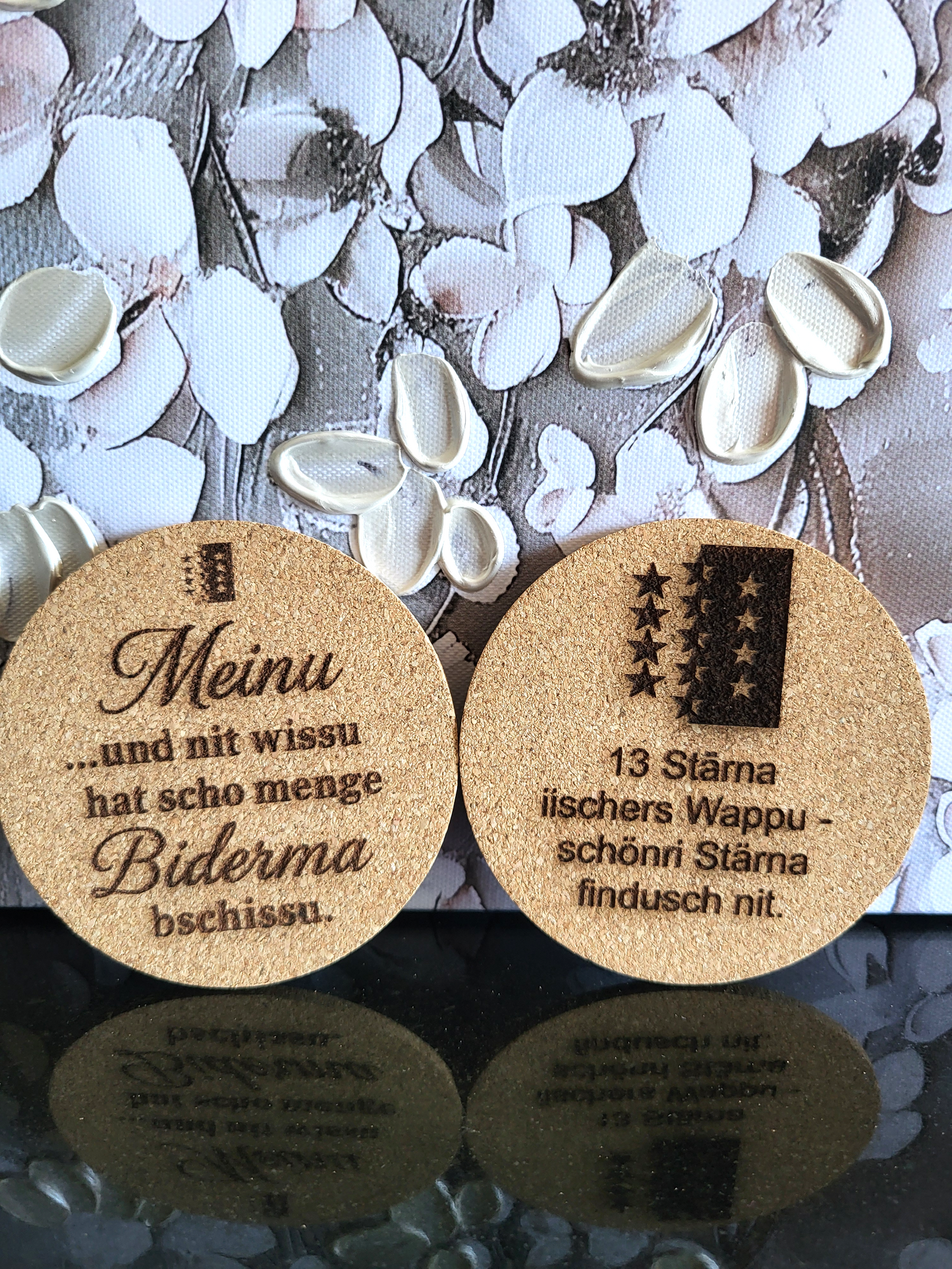 Zwei lasergravierte Kork-Untersetzer mit dem Walliser Wappen und Sprüchen in Walliser Mundart.