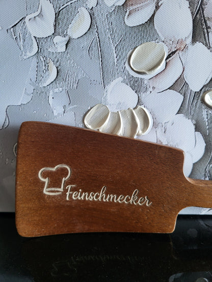 Gravierte Bratschaufel aus Akazienholz mit dem Spruch "Feinschmecker". Dieses Küchenutensil ist das perfekte Geschenk für Feinschmecker, Hobbyköche und Gourmet-Liebhaber und eine originelle Ergänzung für jede Küche.