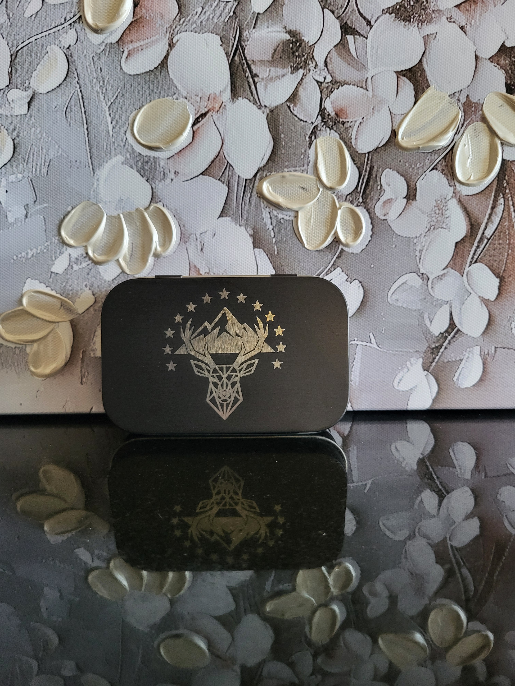 Gravierte Metalldose mit Wallis-Motiv. Die schwarze Box zeigt einen Hirschkopf in einem Bergpanorama, umgeben von 13 Sternen, die den Kanton Wallis symbolisieren. Perfekt als Geschenk oder Souvenir für Walliser oder Liebhaber der Region. Ideal als Aufbewahrungsdose für Kleinteile wie Schmuck, Pillen oder Münzen.