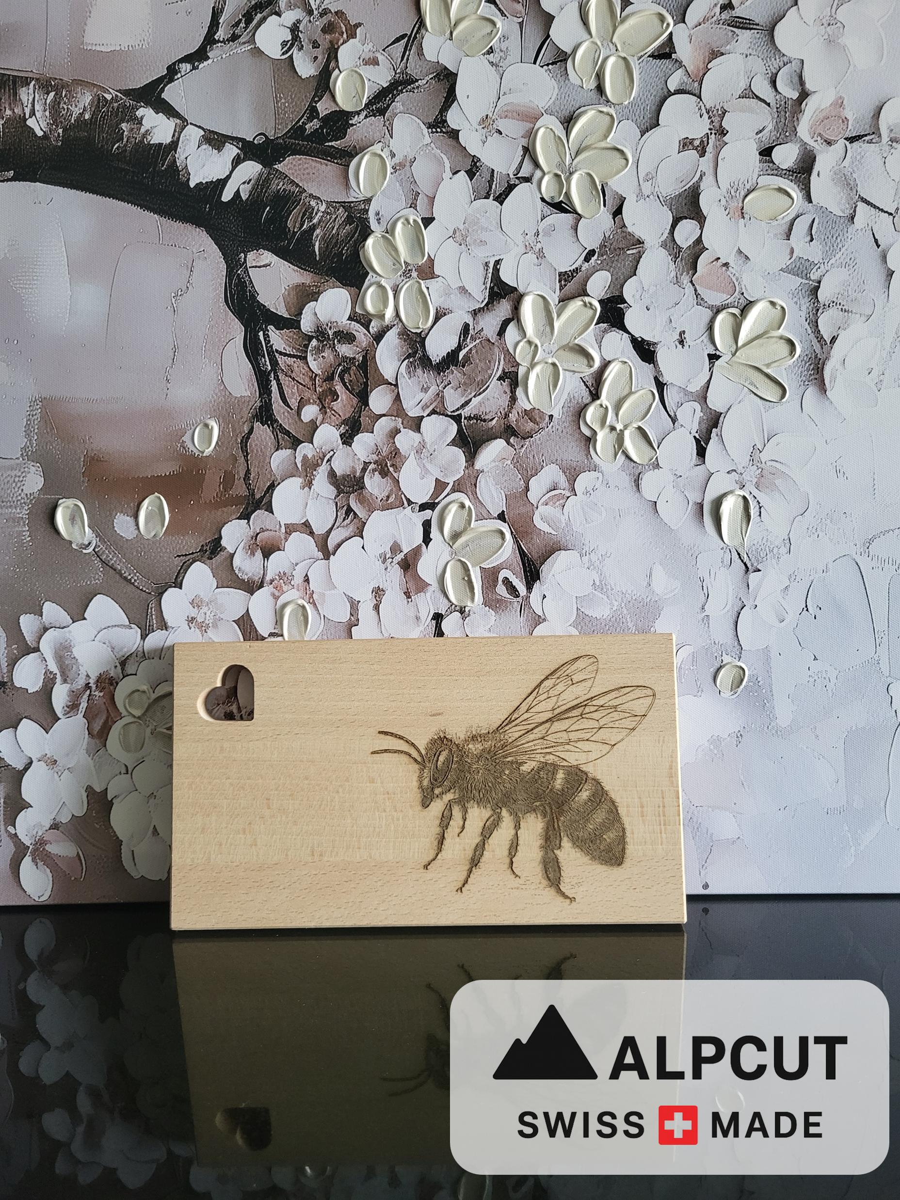 „Schneidebrett aus Schweizer Buchenholz mit Herz-Aussparung und detailreicher Gravur einer Biene – handgefertigt von ALPCUT. Edles, nachhaltiges Holzbrett mit feiner Maserung, ideal als Servierbrett, Käsebrett oder Geschenk für Natur- und Bienenliebhaber. Hochwertige Verarbeitung, langlebig und dekorativ für jede Küche.“