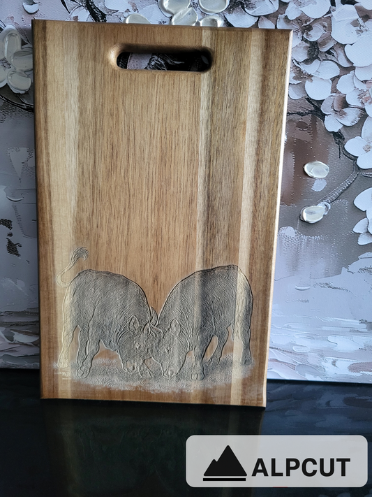 „Schneidebrett aus Akazienholz mit Gravur von zwei Eringer Kühen im Kampf – handgefertigt und einzigartig von ALPCUT. Rustikales Holzbrett mit Schweizer Motiv, ideal als Küchenbrett, Servierbrett oder Geschenk für Kuhliebhaber, Bauernhof-Fans und Schweiz-Freunde. Nachhaltiges Naturholz mit kunstvoller Lasergravur, hochwertig verarbeitet.“