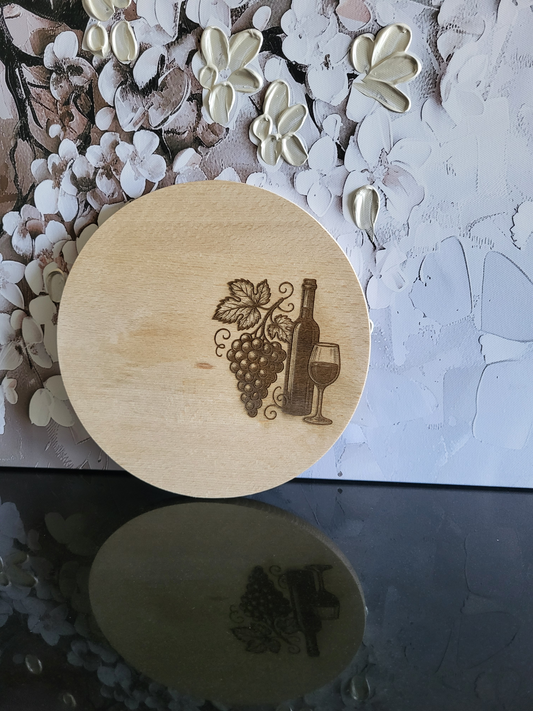 Rundes Brett aus Buchenholz mit einer Wein-Gravur. Ideal als Käse- oder Vesperteller für Weinliebhaber und als stilvolle Geschenkidee. Die Lasergravur zeigt Weintrauben, eine Weinflasche und ein Weinglas.