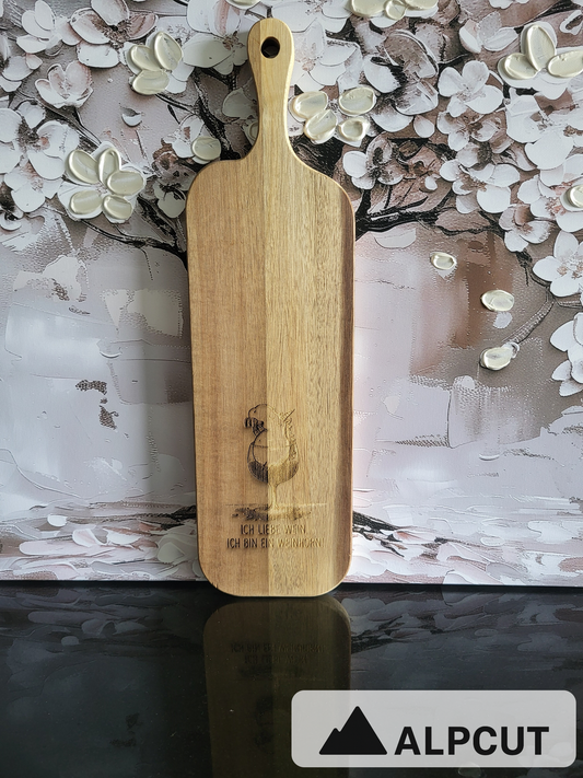 „Servier- und Schneidebrett aus Akazienholz mit Gravur Weinglas und Spruch ‚Ich liebe Wein, ich bin ein Weinhorn‘ – handgefertigt von ALPCUT. Edles Holzbrett mit natürlicher Maserung, ideal als Käsebrett, Apérobrett oder Geschenk für Weinliebhaber. Nachhaltiges Naturholz, hochwertig verarbeitet und mit humorvoller Gravur, perfekt für gesellige Abende.“