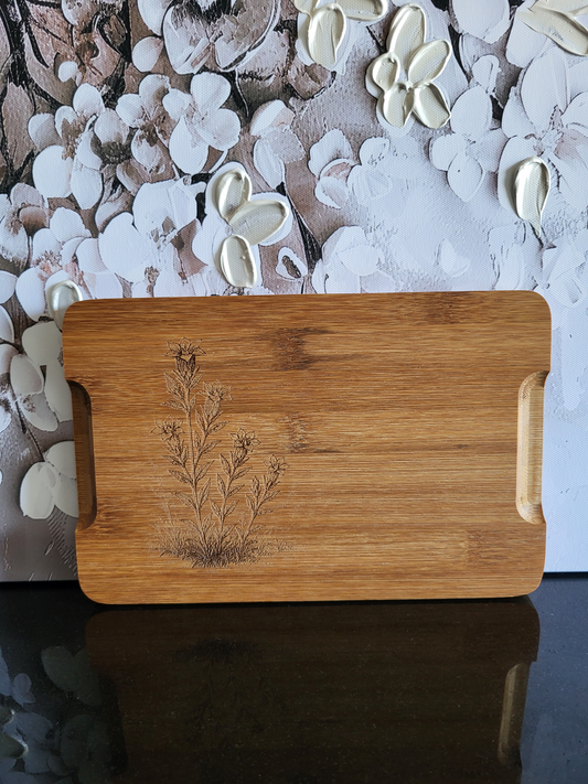 Wendenbares Schneidebrett aus Bambus mit Blumen-Gravur. Die Vorderseite ziert ein kunstvolles Motiv, während die Rückseite eine praktische Saftrinne hat. Ideal als Küchenbrett, Servierplatte oder Schneideunterlage. Perfekt für die Zubereitung von Speisen, die viel Saft abgeben.