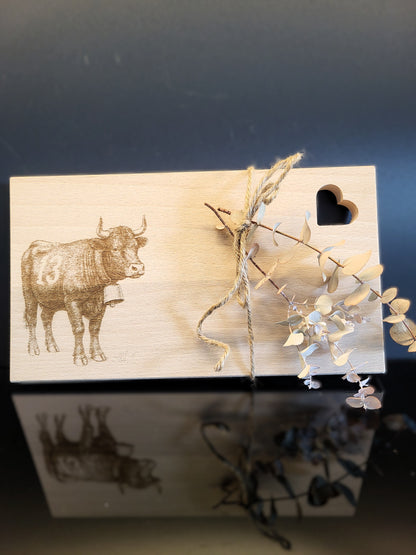 Schneidebrett aus Schweizer Buchenholz mit feiner Gravur einer Eringerkuh und herzförmiger Aussparung. Natürliches, nachhaltiges Holzbrett von AlpCut – ideal als Geschenk, Servierbrett oder Dekoration.