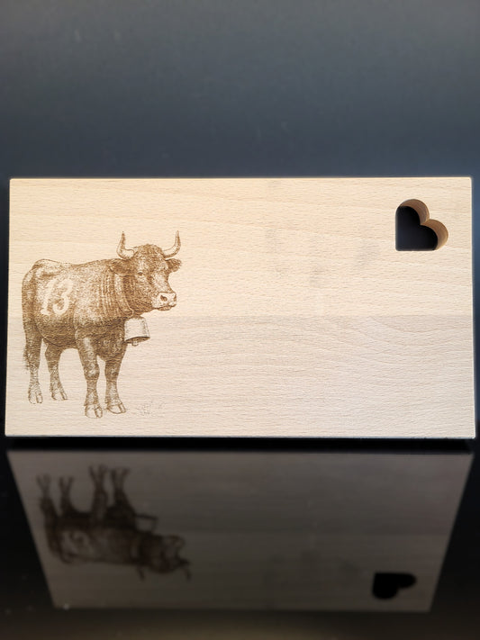 Schneidebrett aus Schweizer Buchenholz mit feiner Gravur einer Eringerkuh und herzförmiger Aussparung. Natürliches, nachhaltiges Holzbrett von AlpCut – ideal als Geschenk, Servierbrett oder Dekoration.