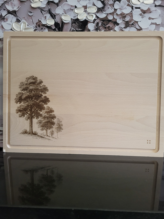 Rechteckiges Schneidebrett aus hellem Buchenholz mit umlaufender Saftrille, schlicht und hochwertig verarbeitet. In der linken unteren Ecke ist eine filigrane Gravur von mehreren Bäumen zu sehen, die detailreich in verschiedenen Größen dargestellt sind und dem Brett eine natürliche, alpine Note verleihen. In der rechten unteren Ecke befindet sich ein dezentes Markenzeichen aus vier kleinen quadratischen Punkten. Das Brett kombiniert Funktionalität mit rustikaler Eleganz und eignet sich sowohl zum Schneiden 