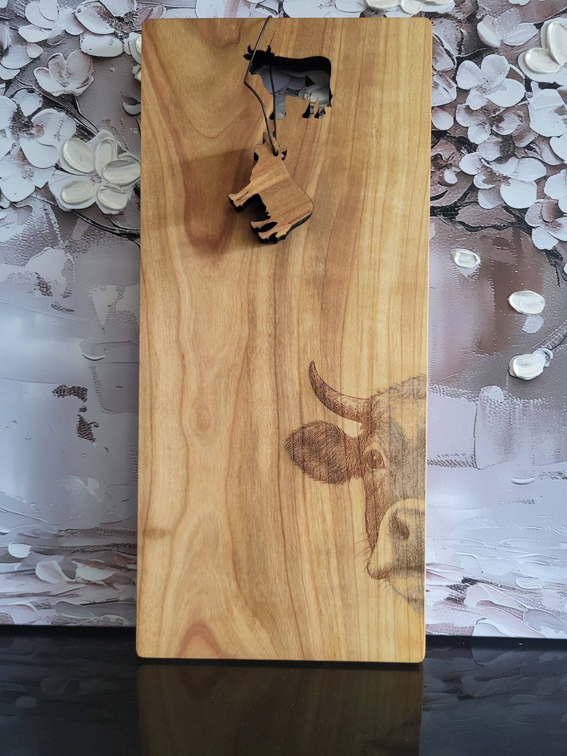 Rechteckiges Schneidebrett aus Kirschholz mit Gravur einer Kuh, inklusive ausgestanztem Kuh-Anhänger, handgefertigt von ALPCUT – rustikales Küchenbrett, Servierbrett und Geschenkidee mit Naturholz-Charakter, ideal für Käse, Brot und Aufschnitt.