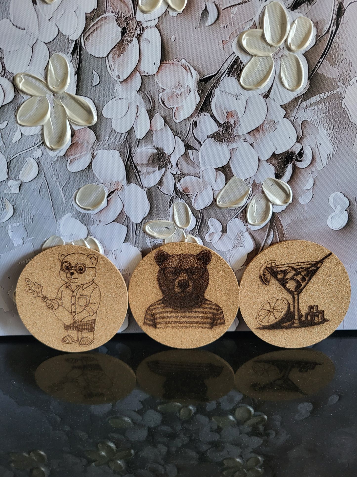 Set aus fünf Korkuntersetzern für Apéro oder Cocktails. Die gravierten Untersetzer zeigen verschiedene Motive wie einen Bären mit Brille, einen Bären im Ringelshirt und ein Martini-Glas. Zwei weitere Untersetzer sind mit den Sprüchen "Lieblingsmensch" und "Besonderen MENSCHEN" beschriftet. Perfekt als Geschenkset für Liebhaber von stilvollem Bar-Zubehör oder als originelles Geschenk für Freunde und Familie.