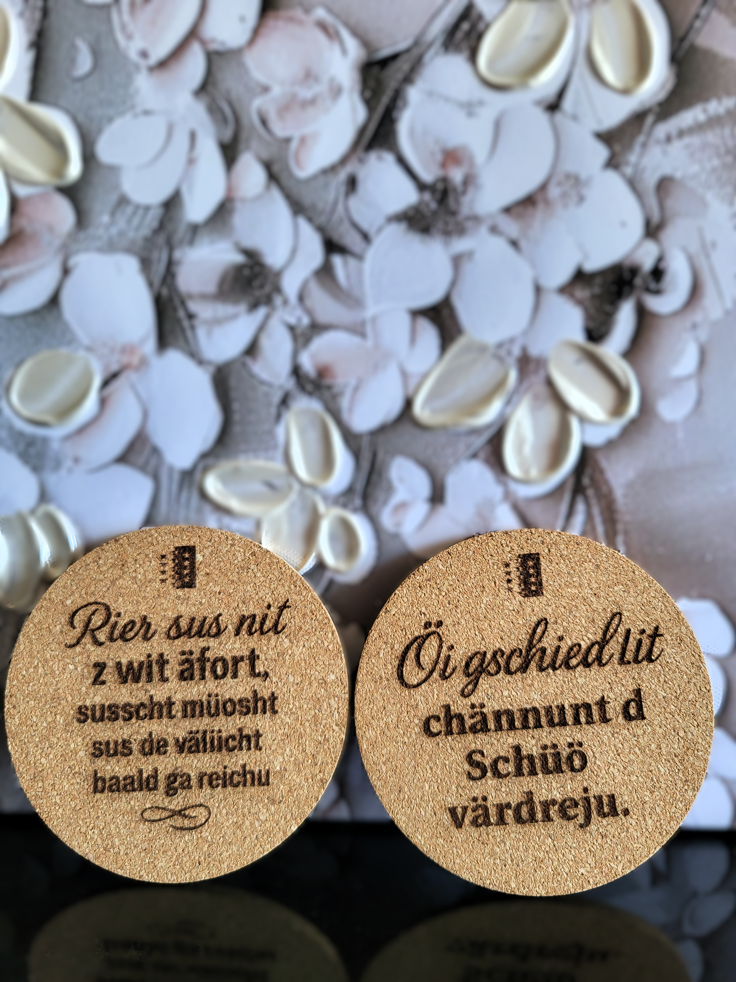 
Handgefertigte Kork-Untersetzer von Alpcut, lasergraviert mit zwei humorvollen Walliser Sprichwörtern im Dialekt: "Rier sus nit z wit afört, susscht müösht sus de välücht baald ga reichu" und "Öi gschied lit chännt d Schüüö värdreju.".