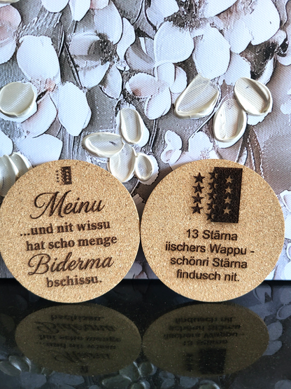 Zwei lasergravierte Kork-Untersetzer mit dem Walliser Wappen und Sprüchen in Walliser Mundart.